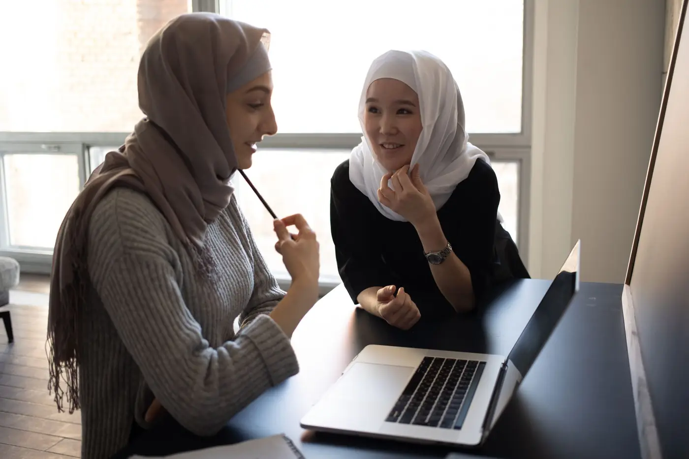 Two students working on a laptop